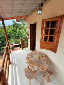 a large wooden table sitting on the porch of a house at Hospedaria Camarão da ilha in Fernando de Noronha