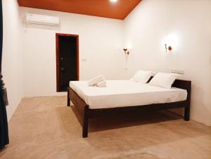 a bedroom with a bed with white sheets and pillows at Cozy Vibe Villa in Arugam Bay