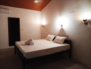 a bedroom with a bed with two pillows on it at Cozy Vibe Villa in Arugam Bay