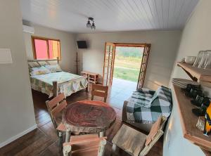 a bedroom with a bed and a table and chairs at Chalés Jatobá in Areias
