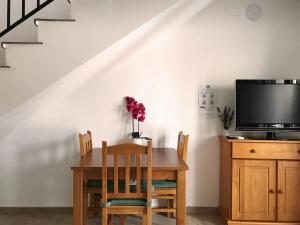 a dining room with a table and a tv at Alojamiento con terraza en Chulilla in Chulilla