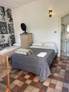 a bedroom with two beds and a table and a table sidx sidx sidx at Suítes da Praça Tiradentes in Tiradentes