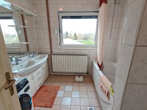 a bathroom with a sink and a bath tub and a sink at Angela Hostel in Fram
