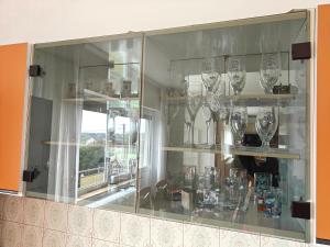 a glass cabinet with wine glasses in it at Angela Hostel in Fram +25 photos