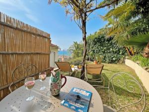 a table with wine glasses and a book on it at Villa Ipomea - Cielo Suite in Salerno