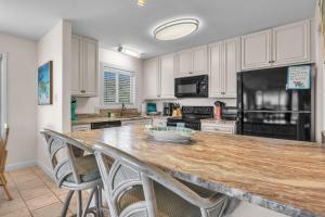 a kitchen with a large wooden counter top with chairs at #7 Ocean Court by Oak Island Accommodations in Caswell Beach