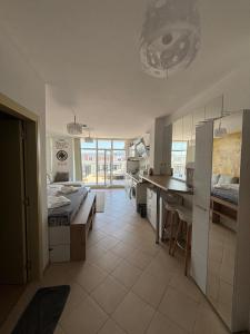 a room with two beds and a desk and a kitchen at Luxury Penthouse Studio with Outdoor Hot Tub and Panoramic Views in Sunny Beach