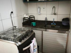 a kitchen with a stove and a sink at Cantinho da Jessi in São Vicente