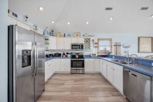 a kitchen with white cabinets and a stainless steel refrigerator at 7680 - Sandy Bottom in Avon +47 photos