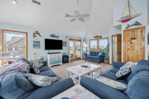a living room with a blue couch and a tv at 7680 - Sandy Bottom in Avon