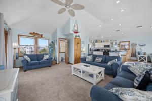 a living room with blue couches and a kitchen at 7680 - Sandy Bottom in Avon