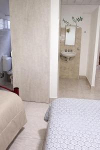 a bedroom with a bathroom with a sink and a bed at Hospedaje Don Felix in General Acha