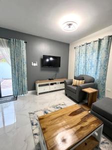 a living room with a couch and a tv at The Cozy Cot in Discovery Bay