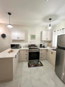 a kitchen with white cabinets and a stove top oven at The Cozy Cot in Discovery Bay