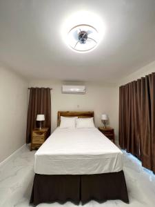a bedroom with a bed with a ceiling fan at The Cozy Cot in Discovery Bay +24 photos