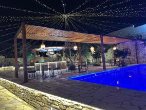 a patio with a bar and a swimming pool at night at Flogeri in Vlorë