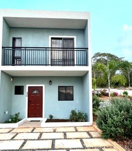 two images of a house with a red door at The Cozy Cot in Discovery Bay