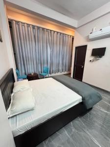 a bedroom with a large bed and a large window at Hotel Dream Crown in Bhopal