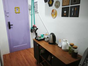 a room with a wooden desk with a purple door at Cantinho da Jessi in São Vicente