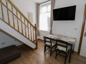 a dining room with a table with two chairs and a television at JMG House in West Bromwich