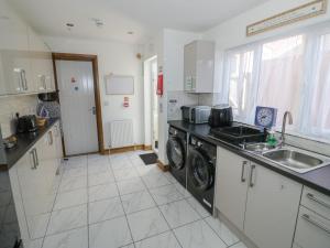 a kitchen with a sink and a washing machine at JMG House in West Bromwich