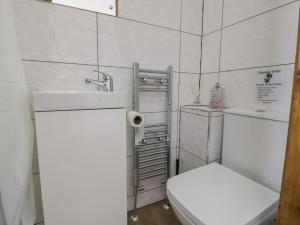 a white bathroom with a toilet and a sink at JMG House in West Bromwich
