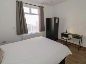 a bedroom with a white bed and a window at JMG House in West Bromwich
