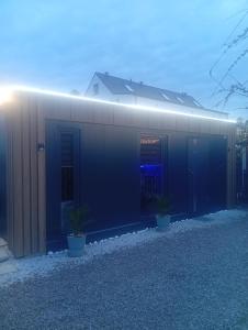 a black building with potted plants in front of it at Domek modułowyBursztynek in Rewa