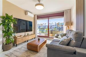 a living room with a couch and a tv at Parque Botanico Resort Country club in Estepona