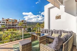a balcony with a couch and a table and chairs at Parque Botanico Resort Country club in Estepona