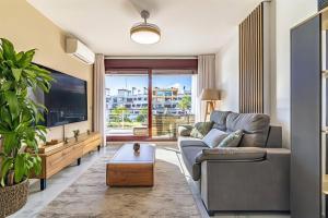a living room with a couch and a tv at Parque Botanico Resort Country club in Estepona +65 photos