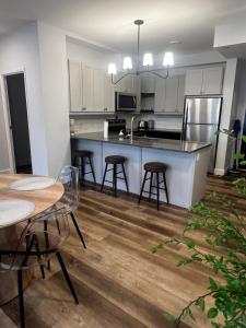 a kitchen with white cabinets and tables and chairs at New The Carlyle 209 Beachside Condo in Grand Bend in Grand Bend +5 photos