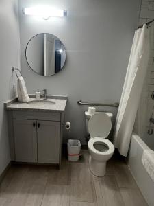 a bathroom with a toilet and a sink and a mirror at New The Carlyle 209 Beachside Condo in Grand Bend in Grand Bend