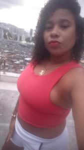 a woman in a red shirt is posing for a picture at Quintal da Gra in Araruama