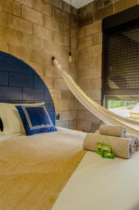 a bed with a hammock in a room with a brick wall at Kazuo520 - Conforto e Minimalismo in Londrina