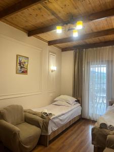 a bedroom with a bed and a chair and a window at Guest House Anahit Ijevan in Ijevan