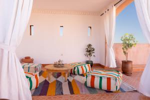 a living room with a table and some chairs at Riad Zinaida in Aït Bou Zguia +108 photos