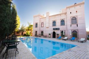 a swimming pool in front of a building at Riad Zinaida in Aït Bou Zguia