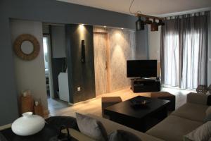 a living room with a couch and a tv at Despina's apts in Kalamariá