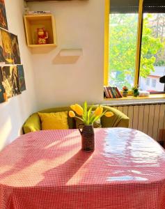 a table with a vase with yellow flowers on it at Oneone eleven hostel in Belgrade