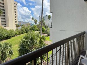 a balcony with a view of a yard with palm trees at 3315-Magic StudioCondo near Universal in Orlando
