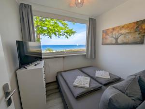 a bedroom with a window and a bed and a television at Panorama-Meerblick am Scharbeutzer Strand in Scharbeutz