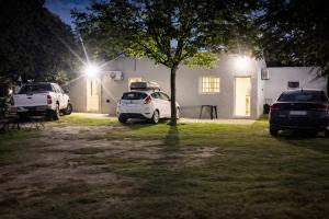 two cars parked in front of a house at night at Hospedaje Don Felix in General Acha
