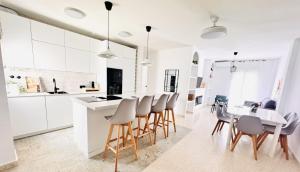a kitchen with white cabinets and a table and chairs at Sala 8 Gran Cinema in Sanlúcar de Barrameda