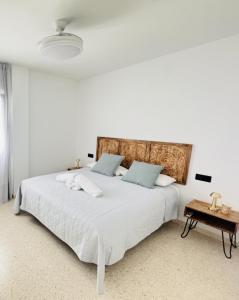 a white bedroom with a large bed and a table at Sala 8 Gran Cinema in Sanlúcar de Barrameda