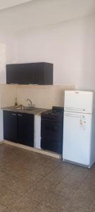 a kitchen with a stove and a white refrigerator at Los Cactus 2 in La Rioja