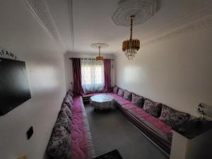 a living room with a couch and a tv at Errachidia Airport Apartment AC 15 Min Walk to Airport Gateway to Merzouga in Oulad el Haj