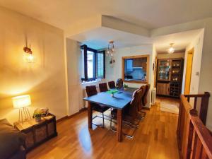 a living room with a wooden table and chairs at Acojedor dúplex en la naturaleza in Valencia de Aneu