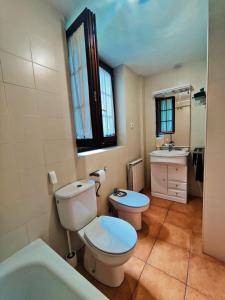 a bathroom with a toilet and a sink and a tub at Acojedor dúplex en la naturaleza in Valencia de Aneu +47 photos