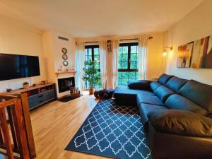 a living room with a blue couch and a television at Acojedor dúplex en la naturaleza in Valencia de Aneu